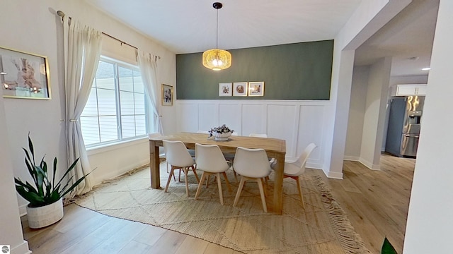 84 9 Mile Rd NW, Comstock Park, MI 49321 - dining space featuring wood finished floors, wainscoting, a decorative wall, and a chandelier