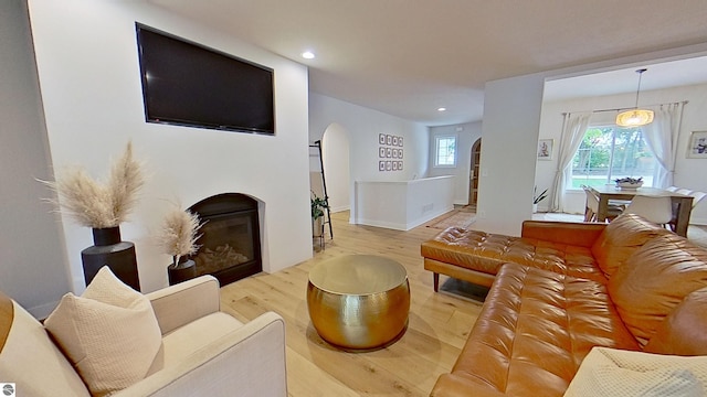 84 9 Mile Rd NW, Comstock Park, MI 49321 - living area with arched walkways, wood finished floors, a glass covered fireplace, and recessed lighting