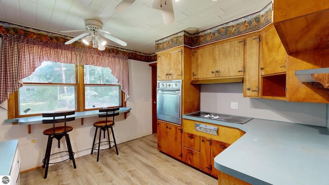 1519 Ridge Rdg, Mount Pleasant, MI 48858 - kitchen featuring oven, ceiling fan, black electric cooktop, light wood finished floors, and brown cabinets