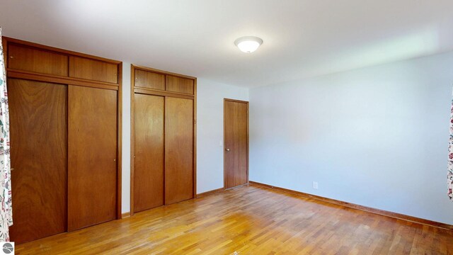 1519 Ridge Rdg, Mount Pleasant, MI 48858 - unfurnished bedroom featuring two closets and light wood-type flooring
