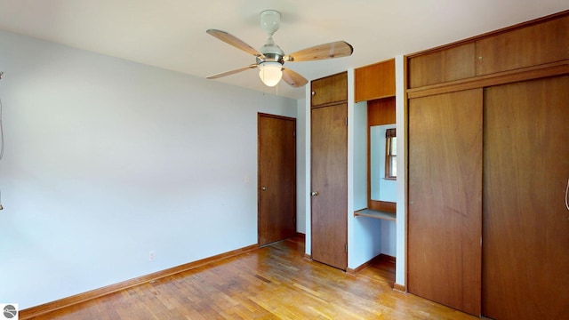 1519 Ridge Rdg, Mount Pleasant, MI 48858 - unfurnished bedroom with multiple closets, light wood-type flooring, and a ceiling fan