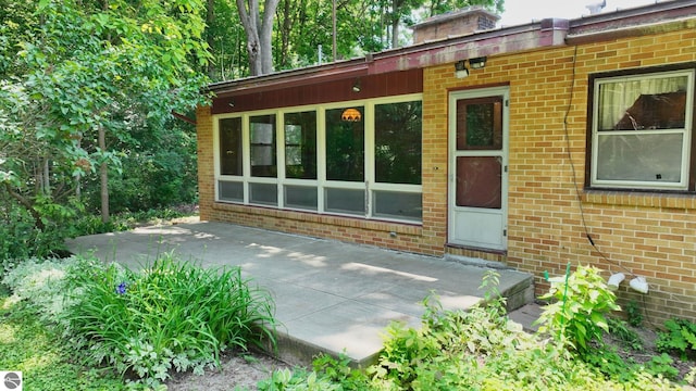 1519 Ridge Rdg, Mount Pleasant, MI 48858 - property entrance featuring a patio area, brick siding, and a chimney