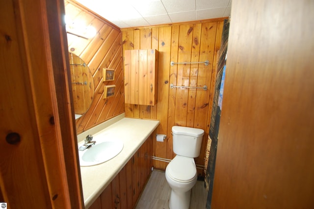 4038 Ogemaw Shores Dr, West Branch, MI 48661 - bathroom with wooden walls, vanity, and wood finished floors
