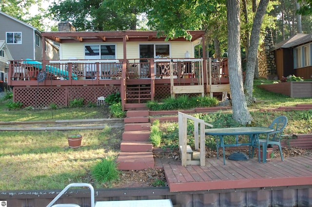 4038 Ogemaw Shores Dr, West Branch, MI 48661 - back of house with a wooden deck, outdoor dining space, and a chimney