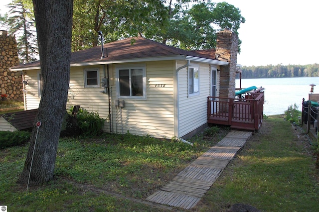 4038 Ogemaw Shores Dr, West Branch, MI 48661 - view of side of home with a chimney, a lawn, and a deck with water view