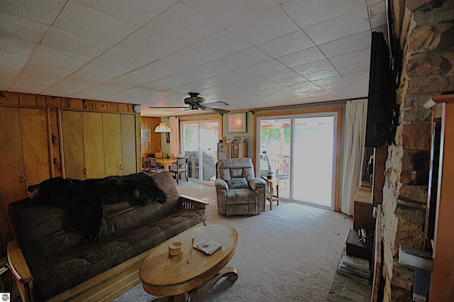 4038 Ogemaw Shores Dr, West Branch, MI 48661 - living room with carpet flooring, wooden walls, and a ceiling fan
