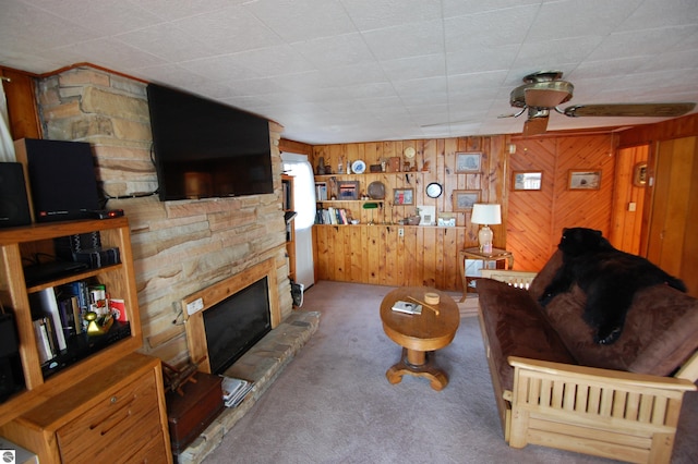 4038 Ogemaw Shores Dr, West Branch, MI 48661 - carpeted living room featuring a stone fireplace, wood walls, and healthy amount of natural light