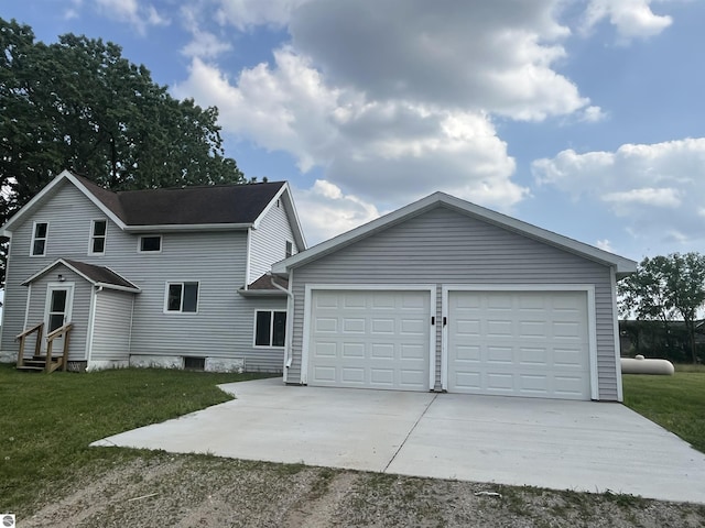2507 N Lincoln Rd, Rosebush, MI 48878 - view of front facade featuring concrete driveway, entry steps, a front yard, an outbuilding, and an attached garage