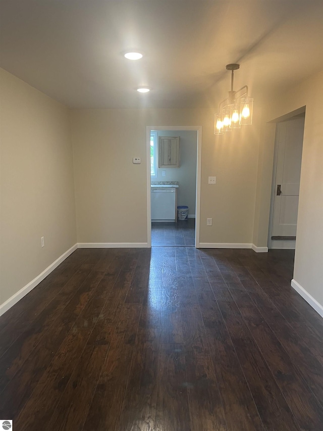 2507 N Lincoln Rd, Rosebush, MI 48878 - unfurnished room featuring dark wood-style floors and a chandelier