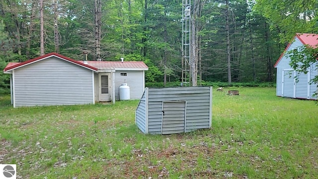 1947 NE Anita Rd, Kalkaska, MI 49646 - view of grassy yard featuring a storage unit and a wooded view