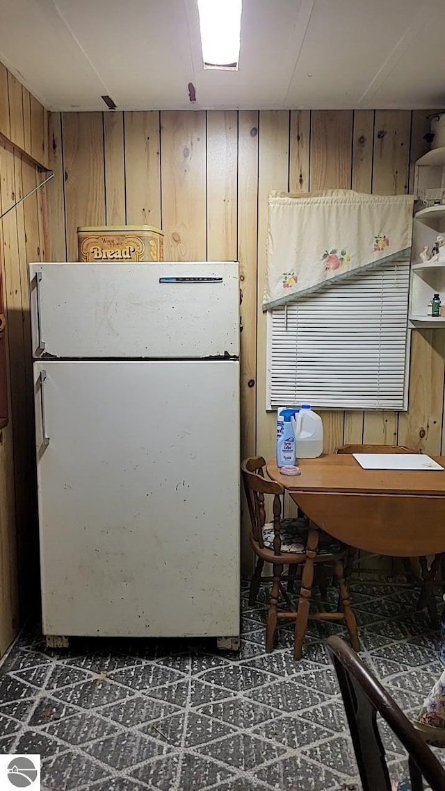 1947 NE Anita Rd, Kalkaska, MI 49646 - kitchen featuring wood walls, freestanding refrigerator, and open shelves
