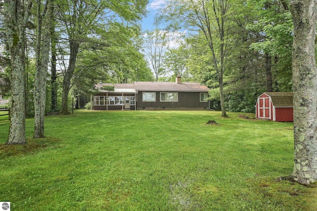 7786 N Shore Ct, Grawn, MI 49637 - view of front of house with a shed, a sunroom, a chimney, and a front yard