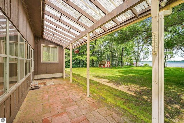 7786 N Shore Ct, Grawn, MI 49637 - view of patio featuring a water view, a pergola, and an outbuilding