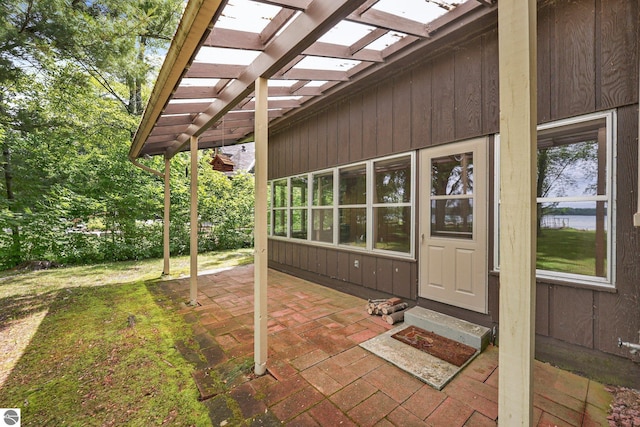 7786 N Shore Ct, Grawn, MI 49637 - view of exterior entry with a pergola and a patio
