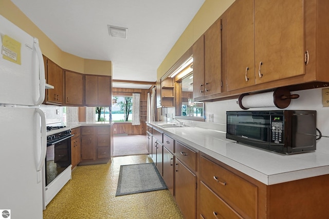 7786 N Shore Ct, Grawn, MI 49637 - kitchen with freestanding refrigerator, gas range oven, black microwave, and light countertops