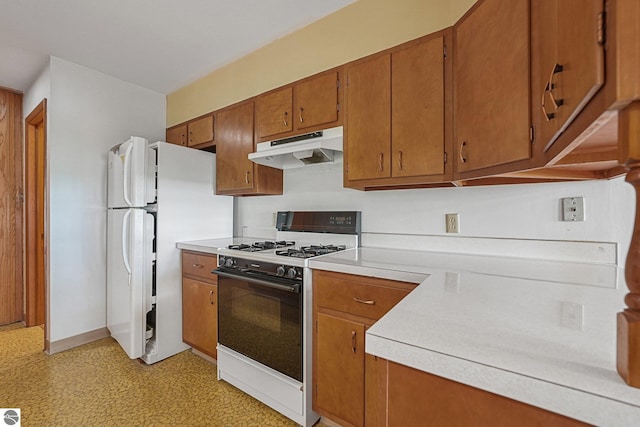 7786 N Shore Ct, Grawn, MI 49637 - kitchen featuring under cabinet range hood, gas stove, brown cabinets, and light countertops