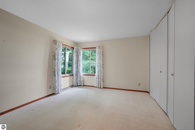 7786 N Shore Ct, Grawn, MI 49637 - unfurnished bedroom with light carpet and a closet
