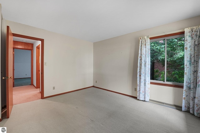 7786 N Shore Ct, Grawn, MI 49637 - spare room featuring light colored carpet and baseboards