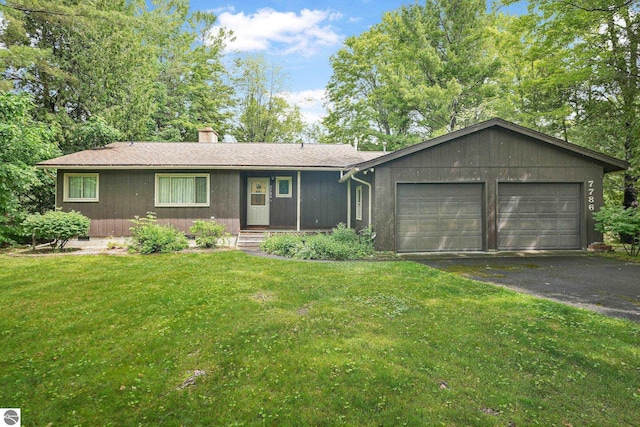 7786 N Shore Ct, Grawn, MI 49637 - ranch-style home featuring a garage, a chimney, driveway, and a front lawn