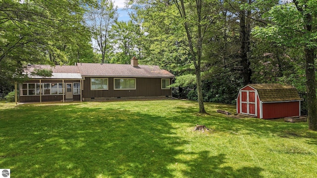 7786 N Shore Ct, Grawn, MI 49637 - rear view of property with crawl space, a storage shed, a sunroom, a chimney, and a yard