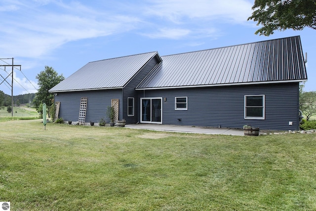 23736 110th Ave, Tustin, MI 49688 - back of house featuring a yard, a patio, and a metal roof