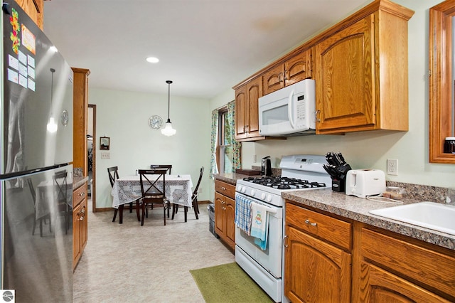 1520 Kuehn Rd, Sterling, MI 48659 - kitchen featuring white appliances, brown cabinets, hanging light fixtures, recessed lighting, and light floors