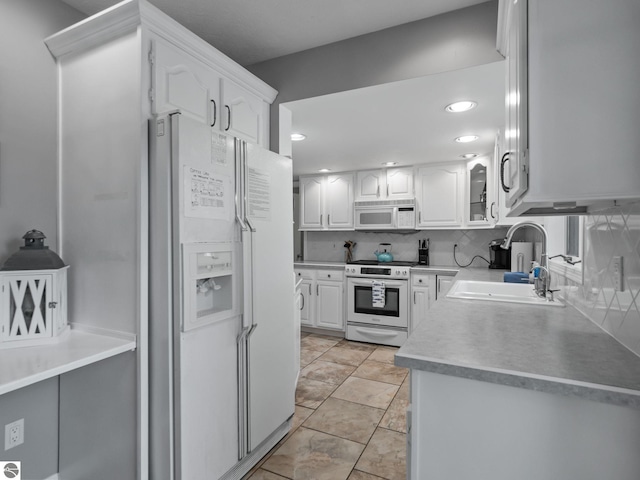 398 High View Rd, Traverse City, MI 49696 - kitchen with white appliances, white cabinets, tasteful backsplash, recessed lighting, and light countertops