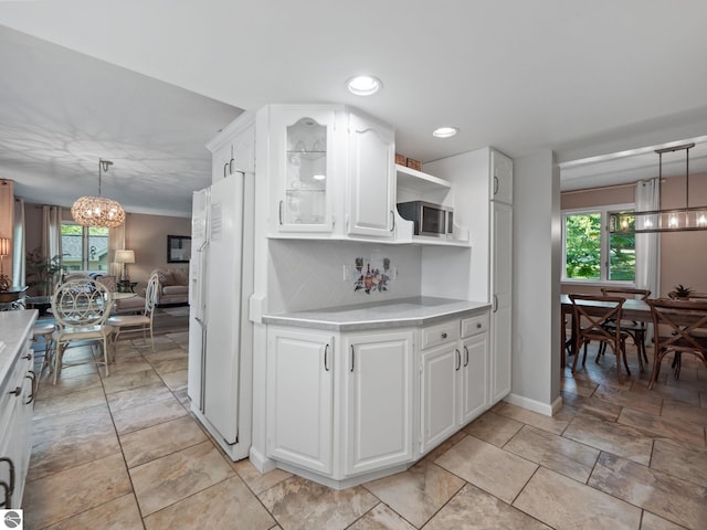 398 High View Rd, Traverse City, MI 49696 - kitchen with a chandelier, freestanding refrigerator, light countertops, healthy amount of natural light, and recessed lighting