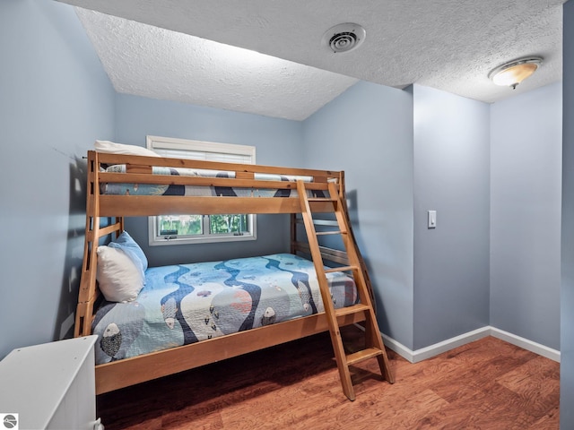 398 High View Rd, Traverse City, MI 49696 - bedroom with wood finished floors and a textured ceiling