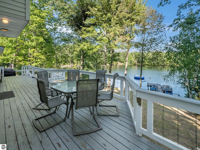398 High View Rd, Traverse City, MI 49696 - wooden terrace with a water view, outdoor dining area, and view of wooded area