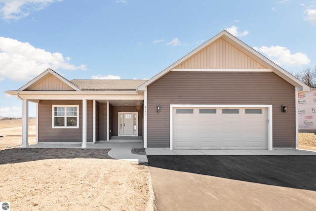 1572 Oban Way, Traverse City, MI 49696 - ranch-style home featuring board and batten siding, a porch, asphalt driveway, and a garage