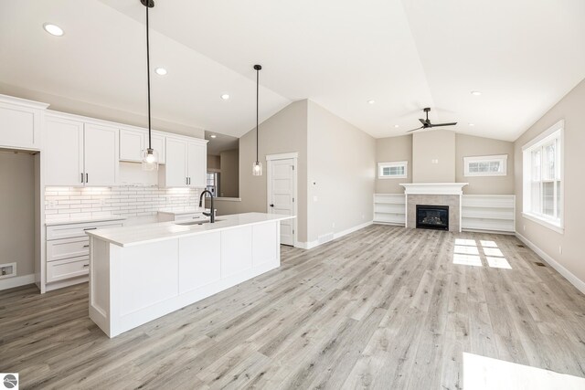 1572 Oban Way, Traverse City, MI 49696 - kitchen featuring ceiling fan, lofted ceiling, white cabinets, light wood-style flooring, and backsplash