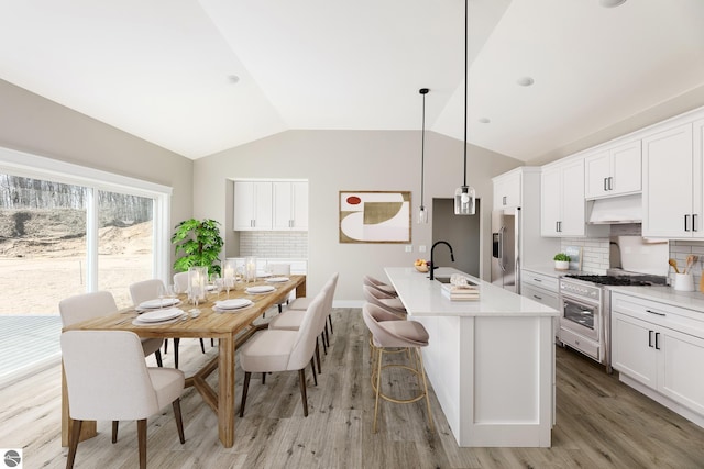 1572 Oban Way, Traverse City, MI 49696 - kitchen with stainless steel appliances, lofted ceiling, light countertops, light wood-style flooring, and tasteful backsplash