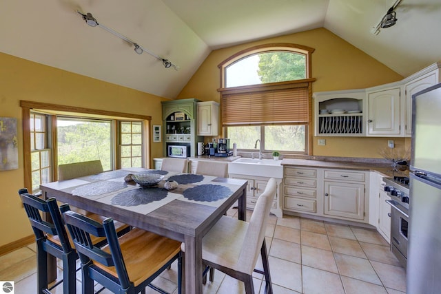 10702 E Hill Top Rd, Suttons Bay, MI 49682 - dining space featuring track lighting, vaulted ceiling, and light tile patterned floors