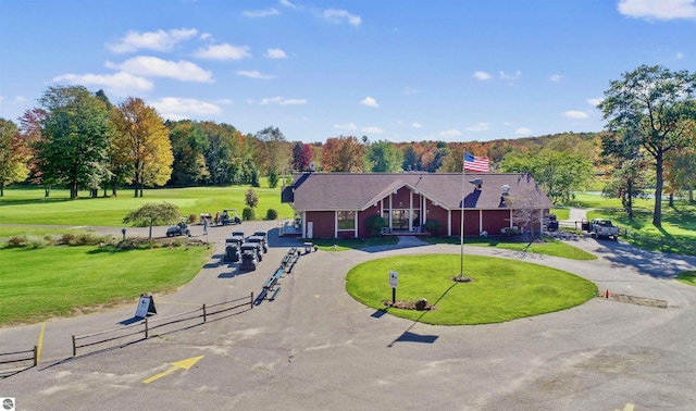 6740 Pheasant Run, Gaylord, MI 49735 - view of front facade with curved driveway, a front lawn, and a chimney