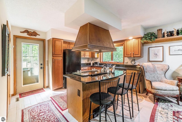 6740 Pheasant Run, Gaylord, MI 49735 - kitchen featuring freestanding refrigerator, plenty of natural light, a breakfast bar, and island range hood