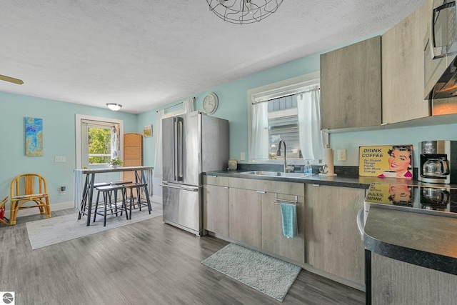 1029 E Front St, Traverse City, MI 49686 - kitchen featuring freestanding refrigerator, dark countertops, dark wood finished floors, and a textured ceiling