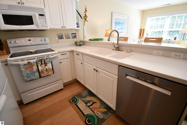 13354 Stover Rd Unit 6, Charlevoix, MI 49720 - kitchen with white appliances, light wood-type flooring, white cabinetry, light countertops, and a peninsula