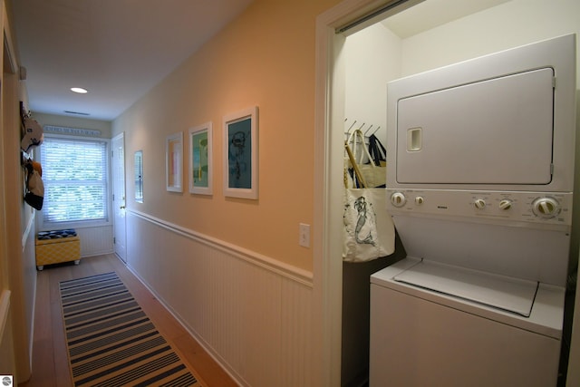 13354 Stover Rd Unit 6, Charlevoix, MI 49720 - laundry area featuring stacked washer / dryer, a wainscoted wall, and wood finished floors