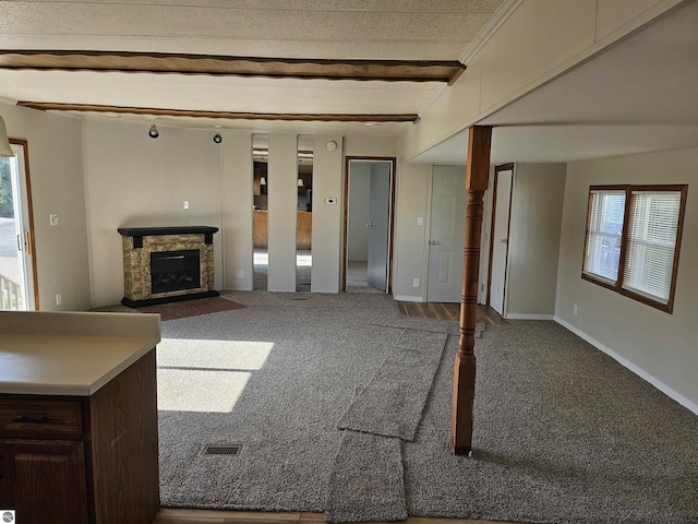 4151 E Jordan Rd Lot 51, Mount Pleasant, MI 48858 - unfurnished living room with carpet floors, healthy amount of natural light, a stone fireplace, and beamed ceiling