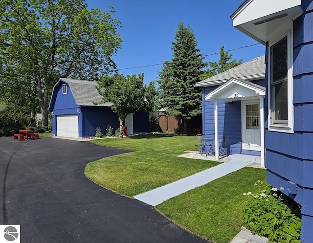 705 E Bay St, East Tawas, MI 48730 - view of grassy yard featuring an outbuilding and a garage