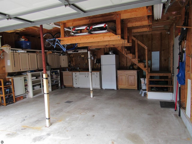 705 E Bay St, East Tawas, MI 48730 - garage with freestanding refrigerator and a workshop area