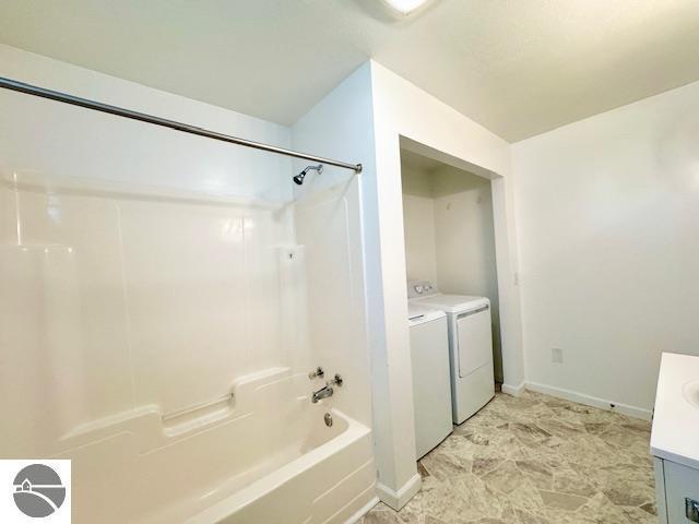 219 Grafton Ave, Alma, MI 48801 - bathroom featuring independent washer and dryer, vanity, and washtub / shower combination