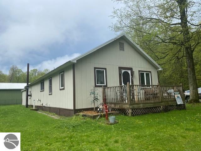 802 W 4th Rd, Buckley, MI 49620 - rear view of house with a wooden deck and a yard