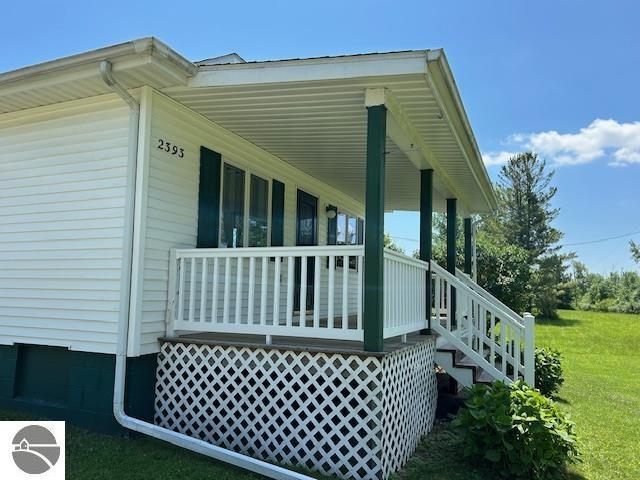 2393 Oates Rd, Tawas City, MI 48763 - view of side of home featuring covered porch and a yard