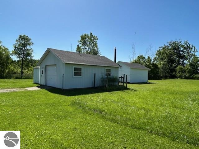 2393 Oates Rd, Tawas City, MI 48763 - back of house with driveway and a lawn