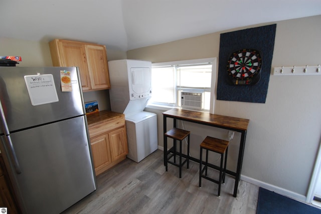 1159 Jones Rd, Saint Helen, MI 48656 - kitchen featuring freestanding refrigerator, stacked washing machine and dryer, cooling unit, light wood finished floors, and light brown cabinets