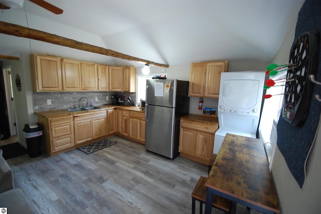 1159 Jones Rd, Saint Helen, MI 48656 - kitchen featuring freestanding refrigerator, vaulted ceiling, light brown cabinetry, estacked washer and dryer, and light wood-style flooring