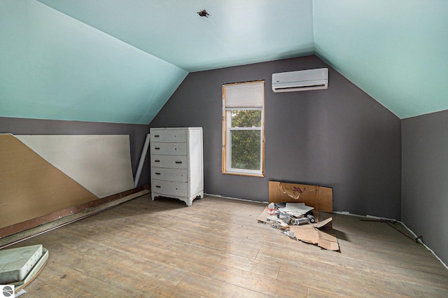 718 Forest Ave, Frankfort, MI 49635 - additional living space featuring a wall mounted air conditioner, vaulted ceiling, and hardwood / wood-style flooring
