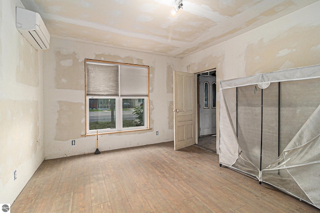 718 Forest Ave, Frankfort, MI 49635 - unfurnished room featuring a wall unit AC and wood-type flooring